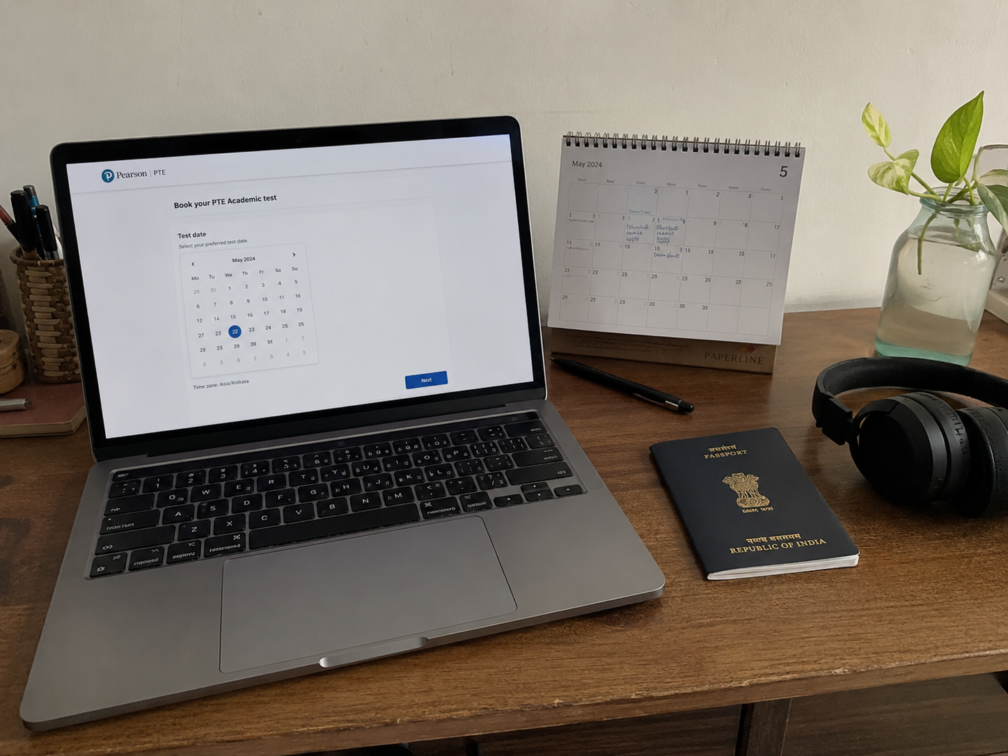 Image idea: realistic study desk + laptop showing a simple PTE booking screen + passport + calendar + headphones. No tables, no infographic, no lots of text.